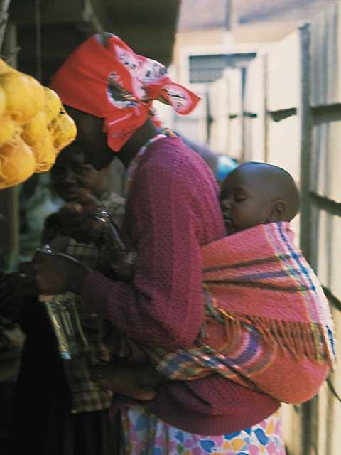 Madre africana con niño en la espalda.